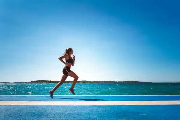 Woman running showing strong leg muscle Cambridgeshire
